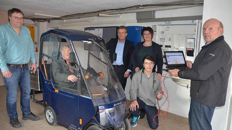 Hier wird das E-Mobil von Josef Behrendt aus dem Speicher der Photovoltaikanlage "aufgetankt" zur nächsten Einkaufsfahrt. Von links: Roland Behrendt, Josef Behrendt, Bürgermeister Rainer Detsch, Sabine und Chris Behrendt sowie Manfred Drechsler, der das Home-Managementsystem installierte und betreuen wird.  Foto: Karl-Heinz Hofmann