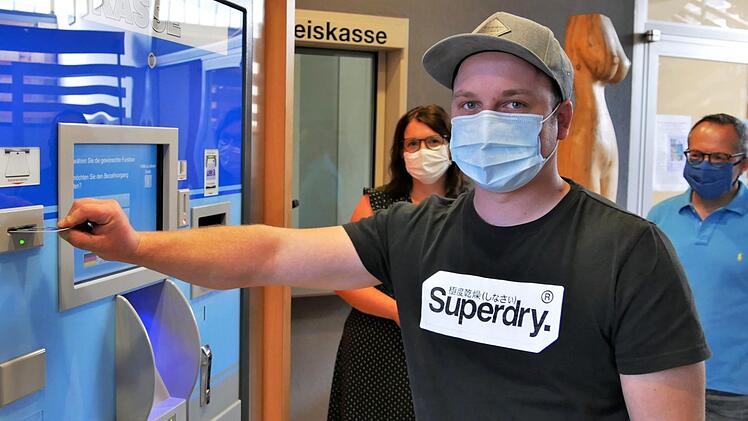 Ein junger Mann zahlt seine KFZ-Geb&uuml;hr am Automaten neben der Kreiskasse. Wenn notwendig, helfen die Mitarbeiter weiter.