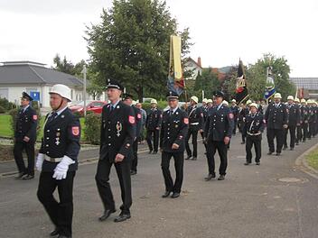 Nach dem Festgottesdienst gingen die Schondras Feuerwehrler zum Kriegerdenkmal. Foto: Oswald Türbl
