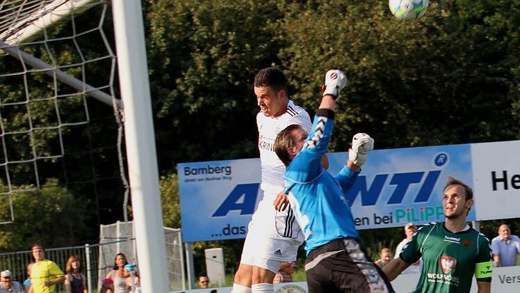 Gästetorwart Stephan Essig faustet  gerade noch dem Sander Maximilian Göbhardt die Flanke vom Kopf. Rechts der Schweinfurter Kapitän Florian Hetzel.
