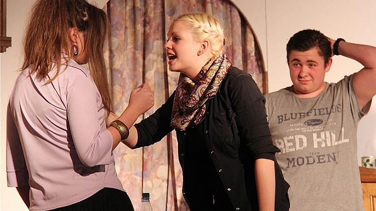 Ehefrau Anna (Anna-Lisa Reith, Mitte) komplimentiert Diana (Meike Breitschopf) aus der Wohnung hinaus. Im Hintergrund Max Huber (Niklas Appel).