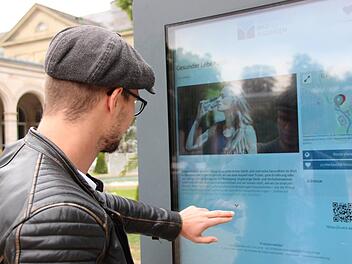 Ein Gast liest an der interaktiven Infostele im Kurgarten. Foto: Benedikt Borst