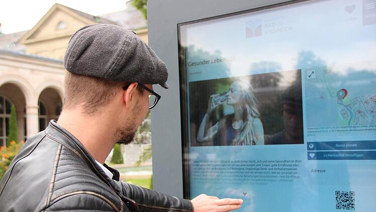 Ein Gast liest an der interaktiven Infostele im Kurgarten. Foto: Benedikt Borst