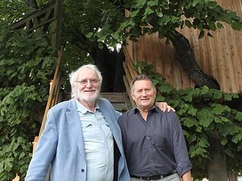 Veit Pöhlmann (links) freut sich, dass Peter Stübinger mit seinen Telstars exklusiv auf der Limmersdorfer Lindenkirchweih auftreten wird. Im Hintergrund ist das Wahrzeichen der Kirchweih zu sehen, die historische Tanzlinde. Foto: Jürgen Gärtner