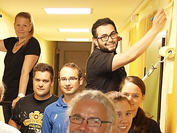 Die Mitarbeiter der Firma Ros malerten im Kinder- und Jugendzentrum Wüstenahorn. Außerdem hatte Geschäftsführer Steffen Tetzlaff einen symbolischen Scheck über 600 Euro dabei. Sozialpädagoge Gerhard Heinzl (vorne, Mitte) freut sich über beides. Foto: Wolfgang Desombre