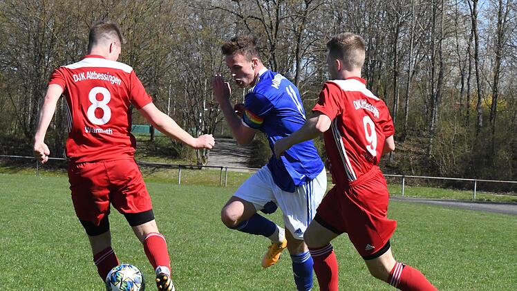 Sieht nach einem Beinschuss aus, den der Altbessinger Pascal Warmuth hier über sich ergehen lassen muss gegen den Münnerstädter Kapitän Lukas Katzenberger. Zum Statisten degradiert ist auch DJKler Marcel Warmuth (rechts). Foto: Hopf