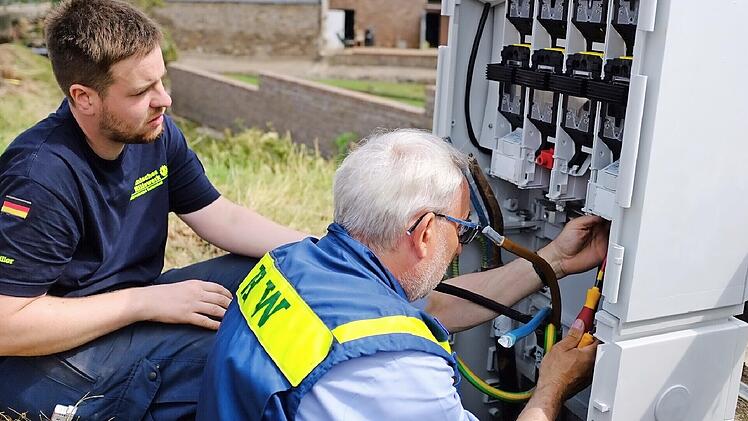 Elektrofachkräfte des THW Ortsverbandes Baiersdorf setzen im Katastrophengebiet einen Stromverteiler instand.