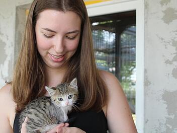 Laura Daum tr&auml;gt K&auml;tzchen Cindy auf dem Arm. Bis sie mit den anderen Katzen spielen darf, muss ihre Operationswunde erst noch verheilen. Foto: Cindy D&ouml;tschel