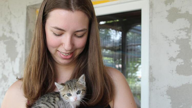 Laura Daum tr&auml;gt K&auml;tzchen Cindy auf dem Arm. Bis sie mit den anderen Katzen spielen darf, muss ihre Operationswunde erst noch verheilen. Foto: Cindy D&ouml;tschel
