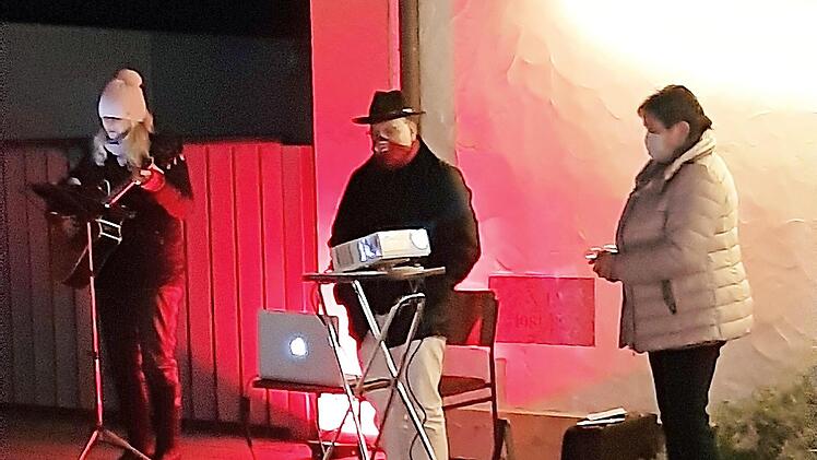 Ganz in Licht getaucht singen und beten sie vor dem Pfarrhaus. Von links Silvia Wachter, Pfarrer Richard Reis und Kornelia Ströhlein  Foto: Susanne Deuerling