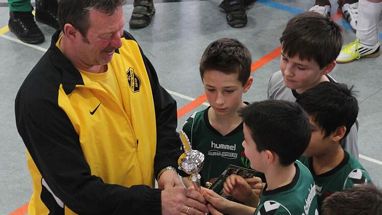 Dettelbachs Organisator Rainer Schimmer überreicht den Pokal an die U11-Sieger vom FC Schweinfurt 05. Foto: Gerd Ludwig