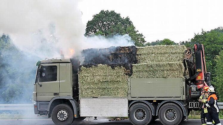 Die Feuerwehren l&ouml;schten die brennenden Heuballen auf dem Lastwagen.  Foto: Herbert Fischer