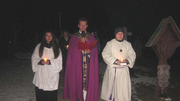 Pfarrvikar Matthias Schmitt f&uuml;hrte die kleine Lichter-Wallfahrtdurch den Kapellenfriedhof an.  Foto: Werner Eberth