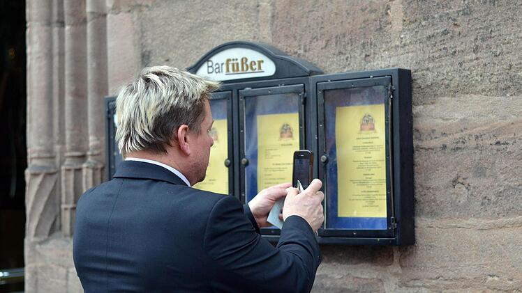 Andenken oder Beweisstück? Ein Passant fotografiert die Speisekarte des Nürnberger Gasthauses. Foto: Pelke