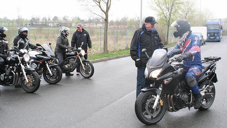 Nach der Übung wird besprochen, was passt und was noch zu verbessern ist. Im Vordergrund Fahrlehrer Gerhard Wust aus Neustadt/Aisch mit einem Teilnehmer. Bei den Motorrädern hinten Siegfried Nürnberger (mit Mütze).
