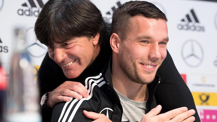 Freundschaftlich verbunden: Bundestrainer Joachim L&ouml;w (links) umarmt Lukas Podolski. Foto: Marius Becker, dpa