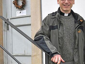 Christian Lutz freut sich auf seine Arbeit als Pfarrer der Pfarreiengemeinschaft Theres, zu der die Pfarreien Gädheim mit Filiale Ottendorf, Obertheres mit den Filialen Buch und Horhausen, Steinsfeld, Untertheres mit Filiale Greßhausen sowie Wonfurt mit Filiale Dampfach gehören. Im Hintergrund ist das Pfarrhaus in Obertheres, das vor dem Einzug des Pfarrers renoviert wird.  Foto: Ulrike Langer