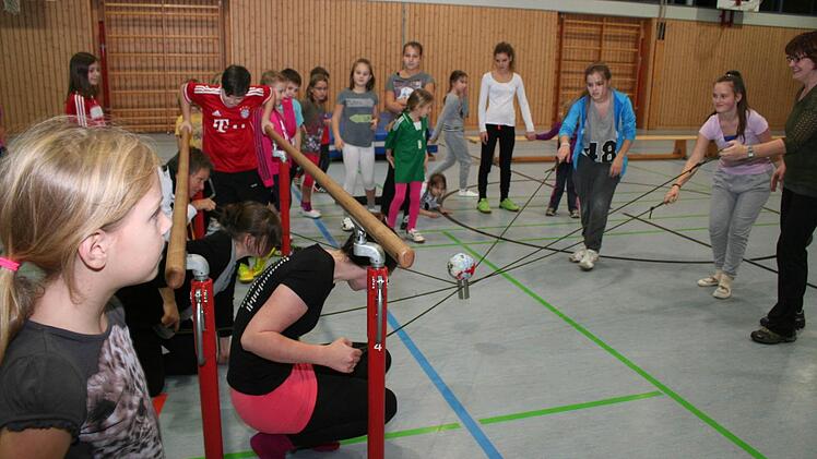 Mit Ball auf dem Seil unterm Barren durch - kein ganz einfaches Vorgehen.