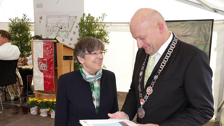 Die oberfränkische Regierungspräsidentin Heidrun Piwernetz übergibt Bürgermeister Claus Schwarzmann den Förderbescheid. Foto: Mathias Erlwein