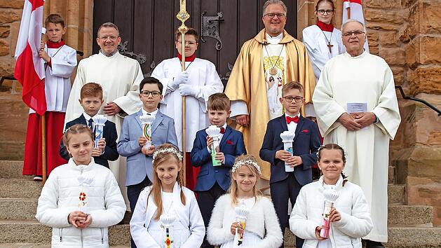 Vor dem Kirchenportal stellten sich die Kommunionkinder der Pfarrei Herz-Jesu Schw&uuml;rbitz mit Ministranten, Wortgottesdienstleitern Manfred K&ouml;nig (links), Horst Habermann (rechts) und Dekan Pfarrer Lars Rebhan (Mitte) zu einem Erinnerungsfoto auf.