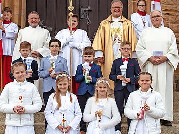 Vor dem Kirchenportal stellten sich die Kommunionkinder der Pfarrei Herz-Jesu Schwürbitz mit Ministranten, Wortgottesdienstleitern Manfred König (links), Horst Habermann (rechts) und Dekan Pfarrer Lars Rebhan (Mitte) zu einem Erinnerungsfoto auf.