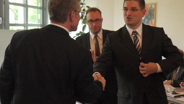 Händedruck für die "Nummer 3": Christian Gunsenheimer (rechts) ist weiterer Stellvertreter des Landrates Michael Busch (links). Zum Abstimmungsergebnis gibt es Applaus vom ULB-Fraktionsvorsitzenden, Markus Mönch. Foto: Berthold Köhler