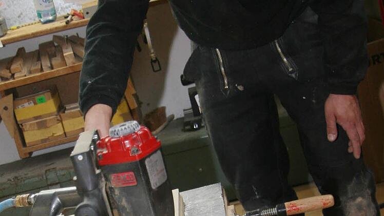 Zimmermeister Frank Dummling bringt mit einem Klammergerät die erste Platte aus. Sie ist aus reinem Fichtenfrischholz und beinhaltet garantiert keine Schadstoffe.