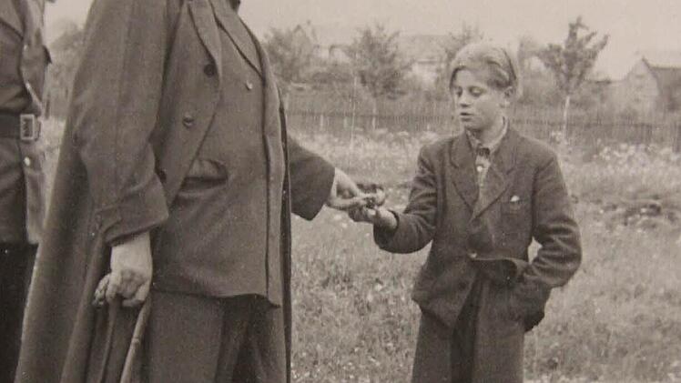 Der damalige Kronacher Bürgermeister Konrad Popp gab einem Flüchtlingsjungen aus Heinersdorf ein Geldstück.  Foto: Archiv Heinlein