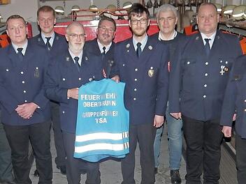 Die Weste für den Gruppenführer bei Einsätzen wandert weiter: (von links) Christian Schilder, Sven Wagner-Baumeister, Martin Göppner, Ralf Hilger, Gerhard Elflein, Martin Schmidt, Bernhard Storath, Ulrich Amon und Timm Vogler.  Foto: Berthold Köhler