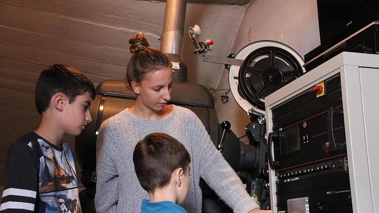 Tobias und Jakob (von links) lassen sich von Kinomitarbeiterin Lena Schneider die Technik im Vorführraum des Zeiler Kinos erklären.Andreas Lösch
