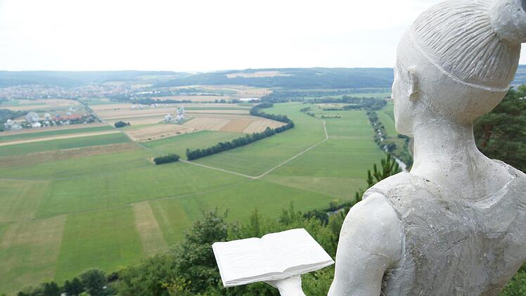 Amalberga blickt mit einem aufgeschlagenen Buch in der Hand wieder ins Saaletal. Foto: Arkadius Guzy