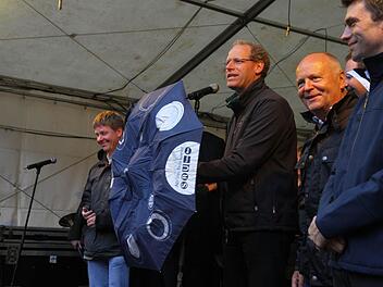 Bei der Eröffnung selber regnete es noch nicht. Aber dunkle Wolken hingen bereits bedrohlich über der Stadt. Bürgermeister German Hacker war aber für alle Fälle gut gerüstet. Fotos: Michael Busch
