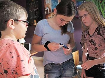 Luka, Lara und Lisa (von links) blicken gespannt auf das Display. Foto: Gerda Völk