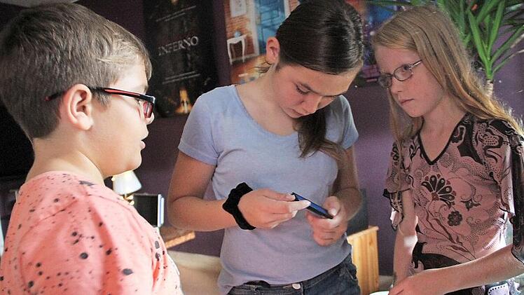 Luka, Lara und Lisa (von links) blicken gespannt auf das Display. Foto: Gerda Völk