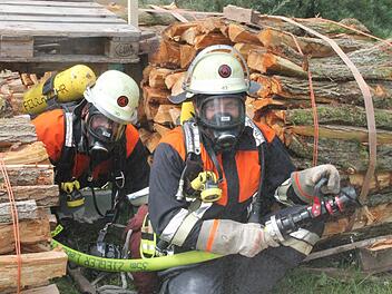 Zwei Atemschutzgeräteträger bei einer Übung. Das Wasser ihres Strahlrohrs soll die Feuerwehrleute im Ernstfall beim Vorgehen und während des Rettens in einem brennenden Gebäude sichern. Foto: Stephan Stöckel.