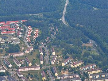 Das Luftbild zeigt, wie eng Natosiedlung, Offizierssiedlung  und das Ankerzentrum beieinander liegen. Die Fläche, die jetzt von der Flüchtlingseinrichtung abgetrennt werden soll, liegt rechts des Kreisverkehrs. Diesem Verkehrsknotenpunkt vorgelagert sind auch die beiden umstrittenen Wohngebäude im Ankerzentrum.  Ronald Rinklef