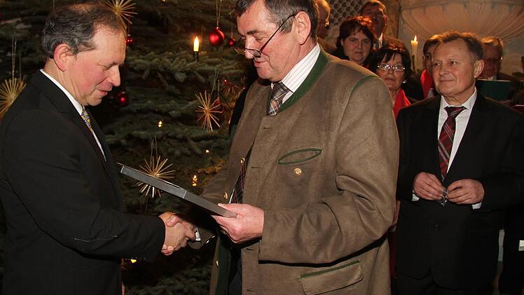 Erhard Hildner (links) überreichte dem verdienten Chorleiter die Ehrennadel für sein 25-jähriges Wirken. Rechts Ewald Lerner, der Vorsitzende des Gesangvereins Kirchleus. Foto: Sonja Adam