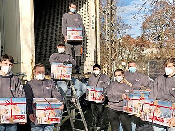 Die Azubis der Unternehmensgruppe Schäflein vor dem Johanniter-Weihnachtstrucker.
