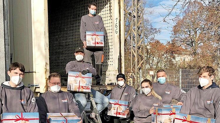 Die Azubis der Unternehmensgruppe Schäflein vor dem Johanniter-Weihnachtstrucker.