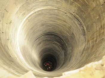 Unrat liegt auf dem Boden des 57 Meter tiefen Brunnens in Königsberg, der zurzeit kein Wasser führt.  Fotos: Gerold Snater