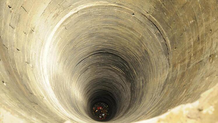 Unrat liegt auf dem Boden des 57 Meter tiefen Brunnens in Königsberg, der zurzeit kein Wasser führt.  Fotos: Gerold Snater