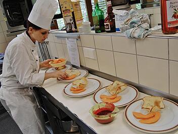 Kunst gehört zum Essen: Eine Auszubildende richtet ihre Desserts an. Foto: Sigismund von Dobschütz