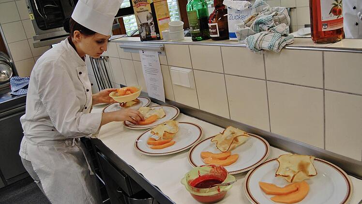 Kunst gehört zum Essen: Eine Auszubildende richtet ihre Desserts an. Foto: Sigismund von Dobschütz