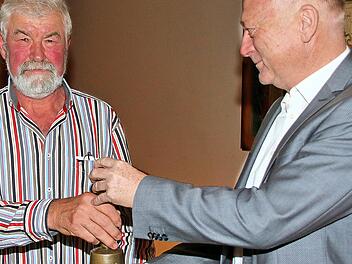 Bürgermeister  Helmut Blank übergibt die Glocke Brünns Ortssprecher Burkard Mohr (links). Britz