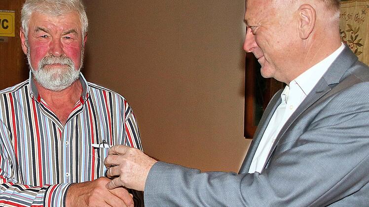 Bürgermeister  Helmut Blank übergibt die Glocke Brünns Ortssprecher Burkard Mohr (links). Britz