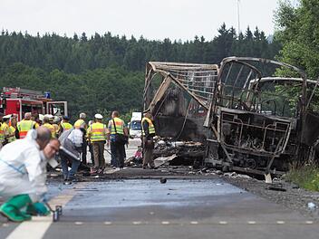 Auf der Autobahn A 9 bei Münchberg war nach dem schweren Busunglück am Montag nur noch ein Gerippe des Busses (r.) und des Anhängers eines Lkw zu sehen. Der Bus war auf einen Lkw am Ende eines Staus aufgefahren und in Flammen aufgegangen.  Foto: Nicolas Armer/dpa
