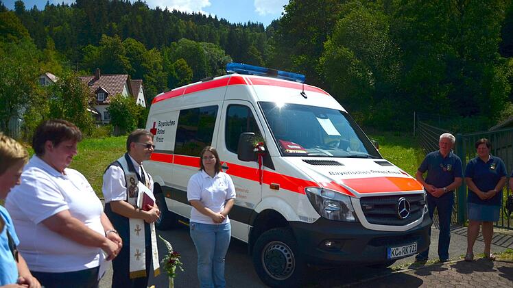 Pfarrer Richard Reis bittet Gott um seinen Segen für das neue Katastrophenfahrzeug der BRK Bereitschaft Steinwiesen. Dritte von rechts Bereitschaftsleiterin Katharina Wunder, links Susanne Deuerling