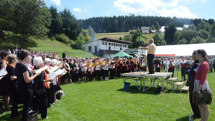 Ehrengruppenchorleiter Walter Klose dirigiert "Candate" vor der herrlichen Kulisse der Chöre. Rechts die beiden Nachfolger, Markus Häßler und Agnes Kauffer. Foto: Karl-Heinz Hofmann
