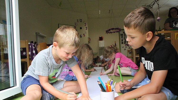 Kinder aus dem Regenbogenland bemalen die Papierrollen, aus denen das größte selbstklebende Bild der Welt entstehen soll. Foto: Ulrike Müller