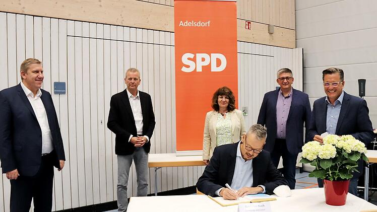 Peter Bofinger trägt sich als Erster ins Goldene Buch ein (stehend v. l.): Andreas Schwarz, Ulrich Maly, Martina Stamm-Fibich, Norbert Lamm und Karsten Fischkal.